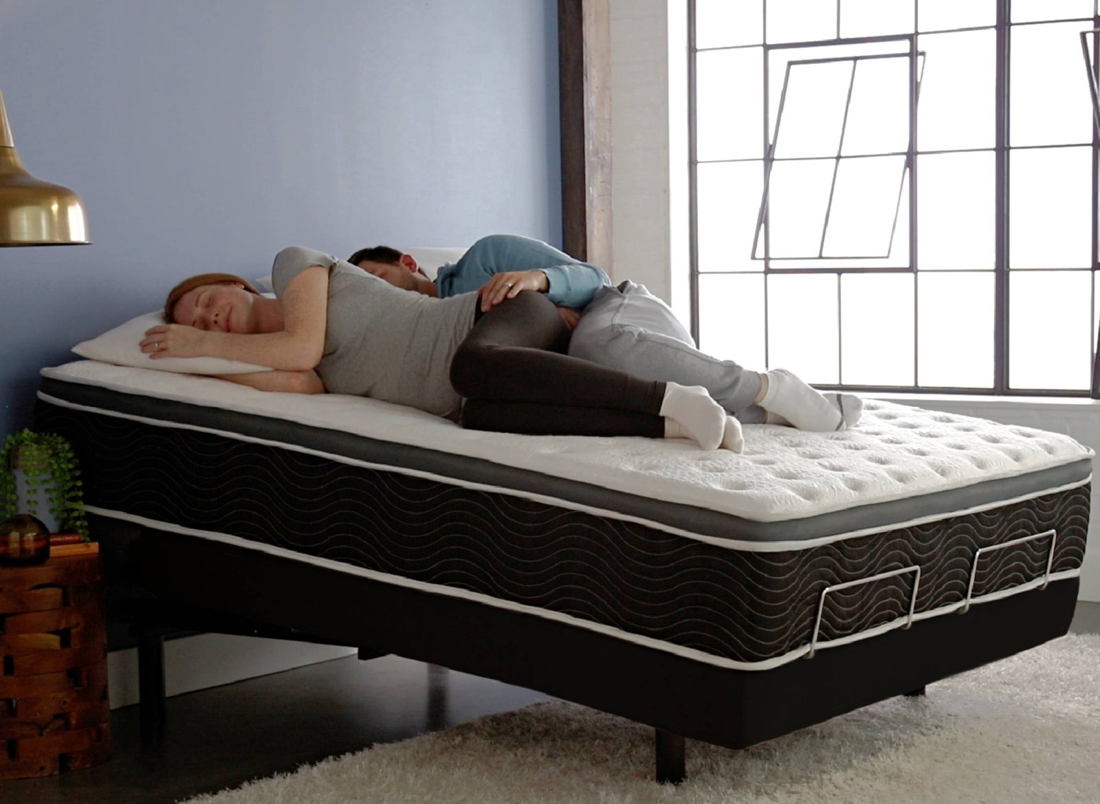 Couple sleeping in tilt position on the black Ergo-Pedic iTilt adjustable base